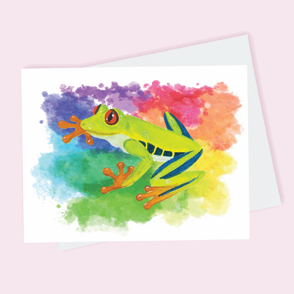 A greeting card depicting a green tree frog with orange feet against a rainbow splatter background done in watercolor.