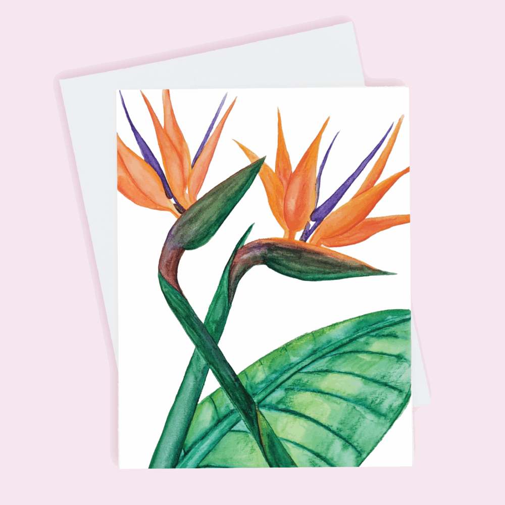 A greeting card depicting two orange Birds of Paradise with green stems and a large green leaf done in watercolor.